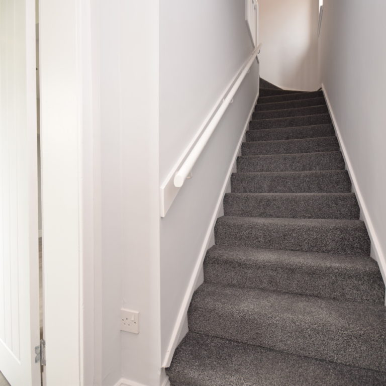 Renovated stairs with grey carpet.