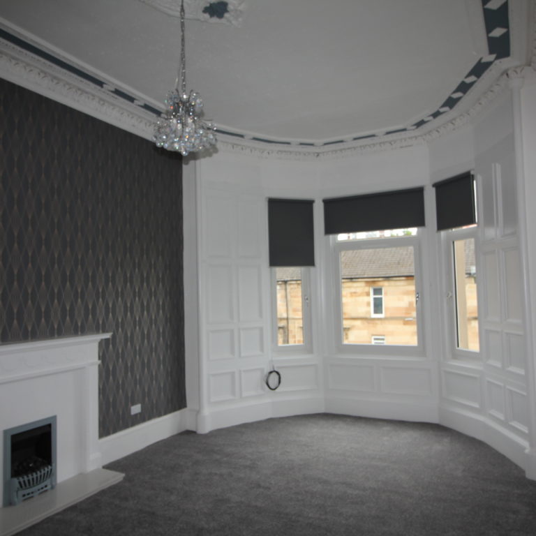 Renovated front room with chandelier and original period features.