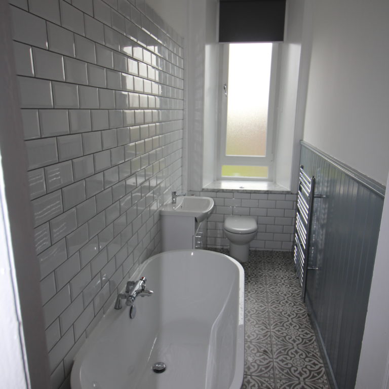 New bathroom with toilet, sink and bath tub installed by MacQueen Property Solutions.